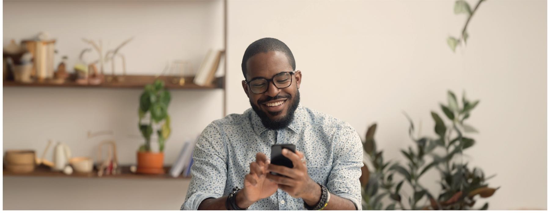 a man smiling and holding a phone