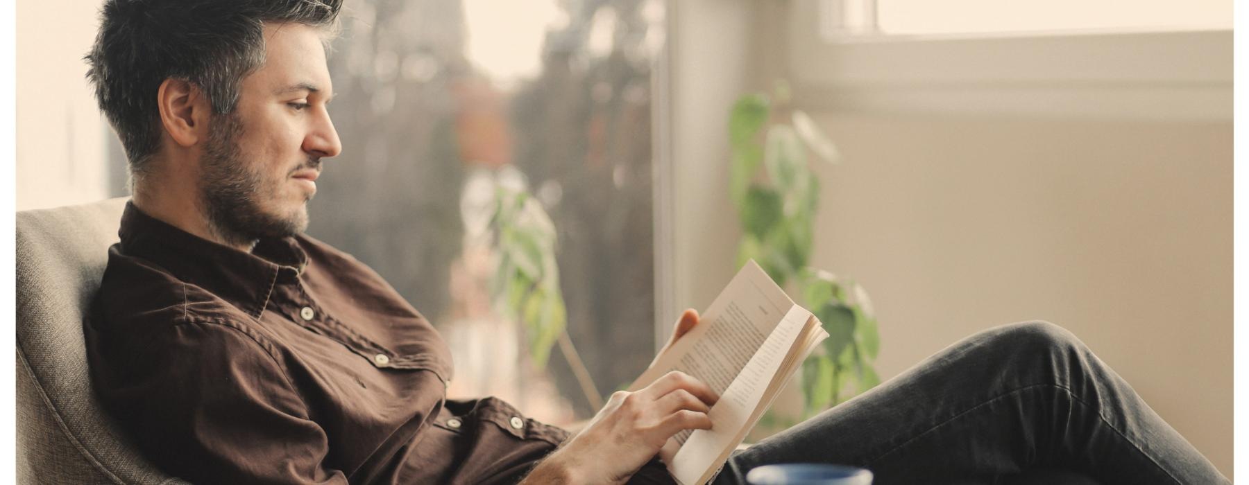 a man sitting at a table reading a book